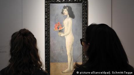 Two women looking at a painting of a woman holding a basket of flowers (picture-alliance/dpa/J. Schmitt-Tegge)