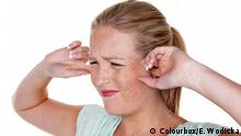 Una mujer se tapa los oídos: tiene tinnitus o acúfeno.