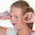 Una mujer se tapa los oídos: tiene tinnitus o acúfeno.