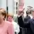 Angela Merkel (e.) chega à cerimônia de entrega do Prêmio Carlos Magno em maio, ao lado de Emmanuel Macron