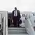 Peter Altmaier descends the stairs from a plane