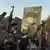 Men loyal to Muqtada al-Sadr wave guns in the air