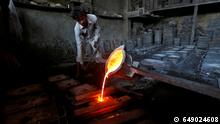 FILE PHOTO: A worker pours molten iron from a ladle to make lamp posts inside an iron casting factory in Ahmedabad, India March 1, 2017. REUTERS/Amit Dave/File Photo