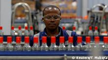 FILE PHOTO: An employee inspects Kenya Cane spirit bottles on a conveyor belt at the East African Breweries Limited factory in Ruaraka factory in Nairobi, Kenya April 6, 2018. Picture taken April 6, 2018. REUTERS/Thomas Mukoya/File Photo