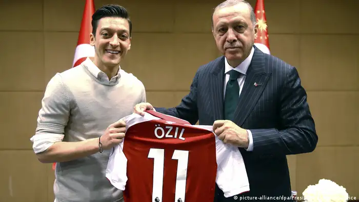 Özil pictured handing a football jersey to Erdogan (picture-alliance/dpa/Uncredited/Presdential Press Service)
