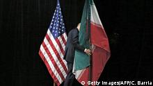 A staff removes the Iranian flag from the stage after a group picture with foreign ministers and representatives of Unites States, Iran, China, Russia, Britain, Germany, France and the European Union during the Iran nuclear talks at the Vienna International Center in Vienna on July 14, 2015. Iran and six major world powers reached a nuclear deal on Tuesday, capping more than a decade of on-off negotiations with an agreement that could potentially transform the Middle East, and which Israel called an historic surrender. AFP PHOTO / POOL / CARLOS BARRIA (Photo credit should read CARLOS BARRIA/AFP/Getty Images)
