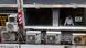 Air conditioning units are seen as a man looks out of a window of a mixed business-residential building in Hong Kong's Central district