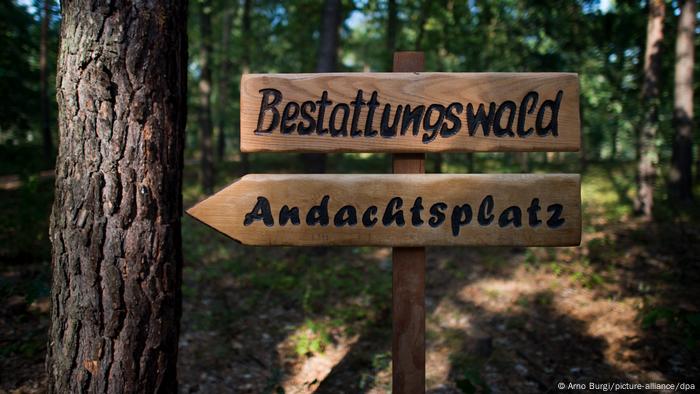 Zwei Hinweisschilder in einem Wald, Bestattungswald und Andachtsplatz