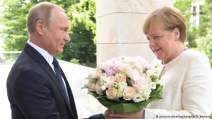 Putin welcomes Merkel with flowers in 2018 (picture-alliance/Sputnik/S. Guneev)