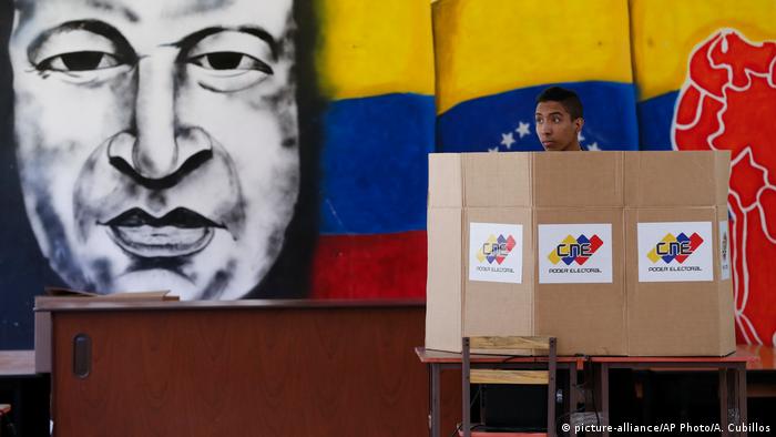 A voter stands behind a cardboard dividerr (APhoto/A. Cubillos) 