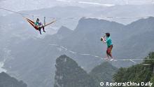 Members of performing group Houle Douce practise their instruments on tightropes ahead of a performance, at the Tianmen Mountain National Park in Zhangjiajie, Hunan province, China May 23, 2018. Picture taken May 23, 2018. China Daily via REUTERS ATTENTION EDITORS - THIS IMAGE WAS PROVIDED BY A THIRD PARTY. CHINA OUT.