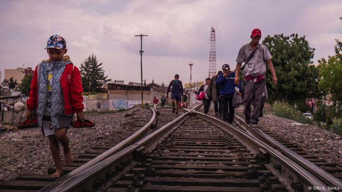 Eine Gruppe Flüchtlinge läuft an Bahnschienen entlang (Foto: DW/S. Derks)