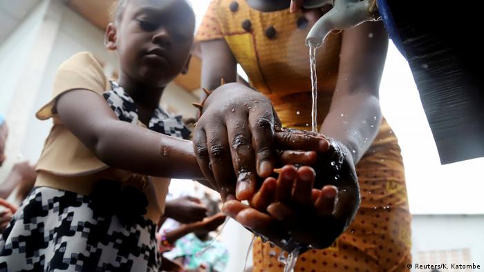 A child washes her hands under a tap in DR Congo