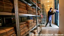 epa000386745 A Romanian policeman holds a pile of files compiled by Securitatea, the former communist secret police, at the warehouse of National Council for Studying the Securitatea Archives (C.N.S.A.S.), in the village of Popesti Leordeni, near Bucharest, Thursday, 10 March 2005. The Romanian Intelligence Service (SRI) has moved the first 6 tons today, from a total of 54 tones of archive, to the CNSAS. All the files will be opened for citizens that will express such request. By the end of 2005, all the files collected by the feared Securitate will be handled to CNSAS. EPA/ROBERT GHEMENT |