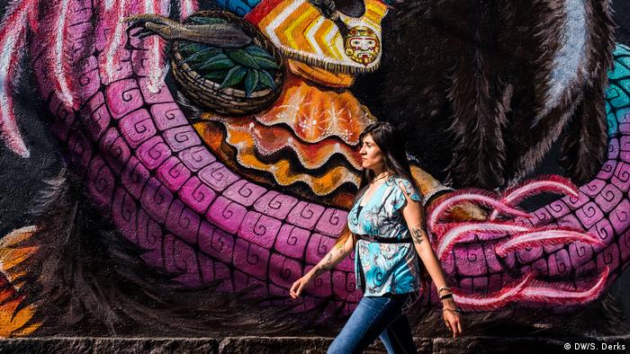 A woman walking past a mural (DW/S. Derks)