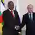 The presidents of the Central African Republic and Russia shake hands in front of the flags of their countries at a meeting in St. Petersburg