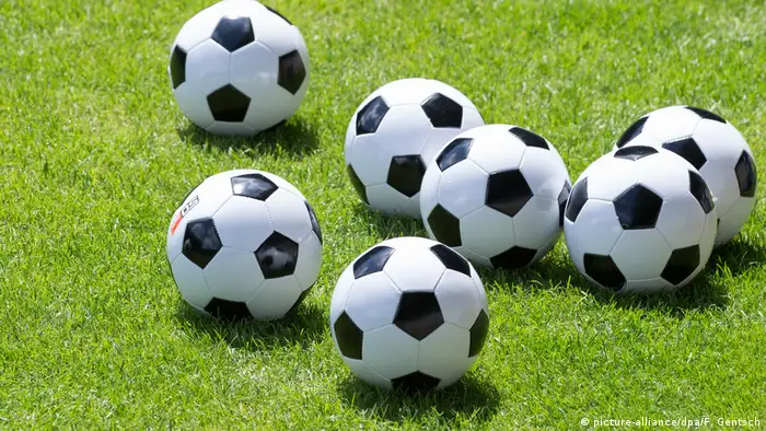Several soccer balls lying on a field (picture-alliance/dpa/F. Gentsch)