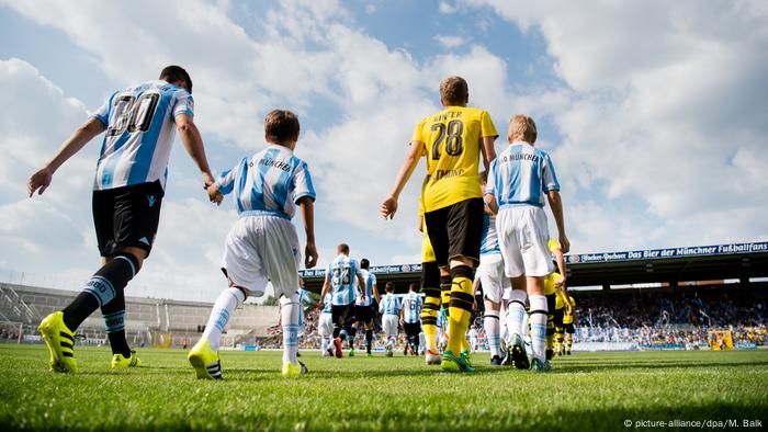 Fußballer betreten mit Auflaufkindern an der Hand den Rasen (picture-alliance/dpa/M. Balk)