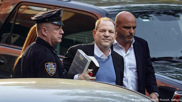 Harvey Weinstein accompanied by a police officer