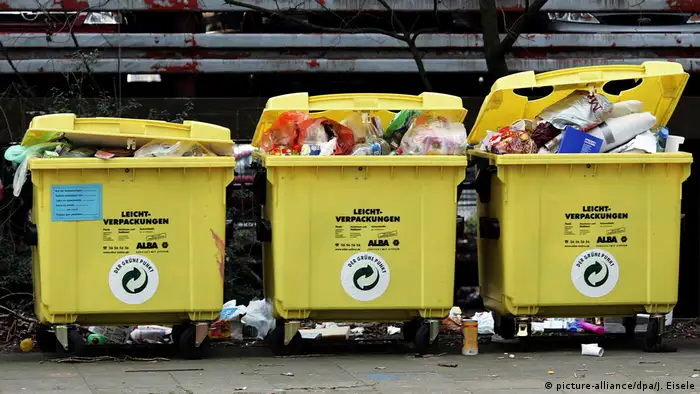 Three yellow bins overflowing with plastic waste