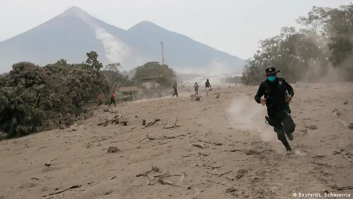 A policeman runs away from the volcano in Guatemala (Reuters/L. Echeverria)