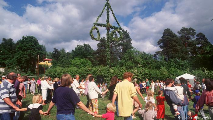 Sweden — people dancing around a midsummer tree 
