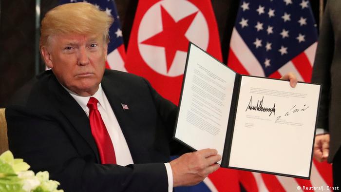 US President Donald Trump shows the document that he and North Korea's leader Kim Jong Un signed (Reuters/J. Ernst)