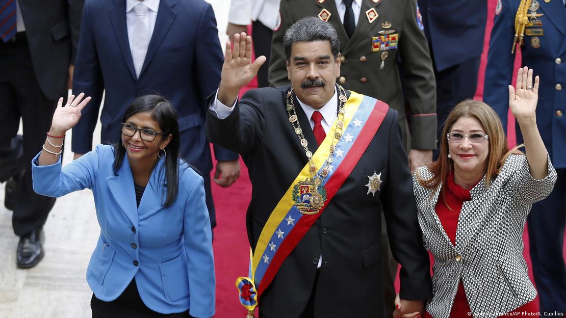 Delcy Rodriguez acena ao lado de Nicolas Maduro e sua esposa, Cilia Flores.