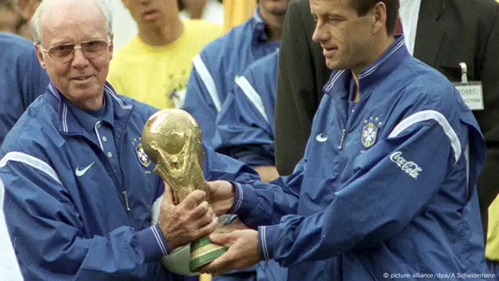 Der brasilianische Trainer Mario Zagallo (l) und Mannschaftskapitän Carlos Dunga (r) tragen am 04.06.1998 in Paris gemeinsam den Fußball-Weltpokal. (picture-alliance/dpa/A.Scheidemann)