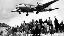 American aircraft drops food and supplies near a crowd of Berliners during the blockade of Berlin (known as the Berlin Airlift) 1948-1949. | Verwendung weltweit
