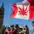 Demonstranten vor dem Parlament mit einer kanadischen Fahne, die statt des Ahornblatts ein Cannabisblatt zeigt