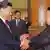 Chinese President Xi Jinping shakes hands with North Korean leader Kim Jong Un in Beijing
