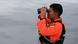 In this June 2018 file photo, a rescue team member uses binoculars to search for missing passengers from a ferry accident In this June 2018 file photo, a rescue team member uses binoculars to search for missing passengers from a ferry accident
