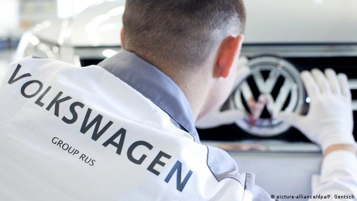 Работник завода Volkswagen в Калуге закрепляет эмблему VW