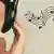 Osoba sa slušalicama na ušima, pored nje nacrtane note