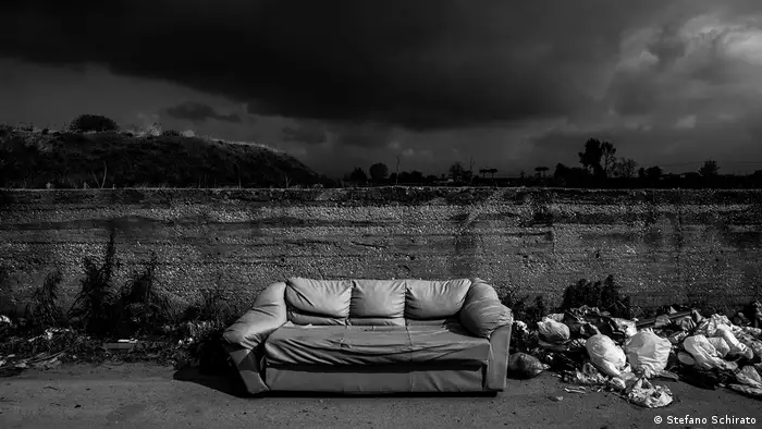 Black sky above landfill with a sofa in the middle (Stefano Schirato)