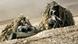 Two camouflaged soldiers lying on the ground, facing observer Two camouflaged soldiers lying on the ground, facing observer