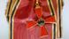 Ein rotes Bundesverdienstkreuz mit rot-gold-schwarzem Schulterband (Foto: Andreas Praefcke) Ein rotes Bundesverdienstkreuz mit rot-gold-schwarzem Schulterband (Foto: Andreas Praefcke)