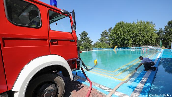Firefighters draw water from a swimming pool (picture-alliance/dpa/J. Woitas)