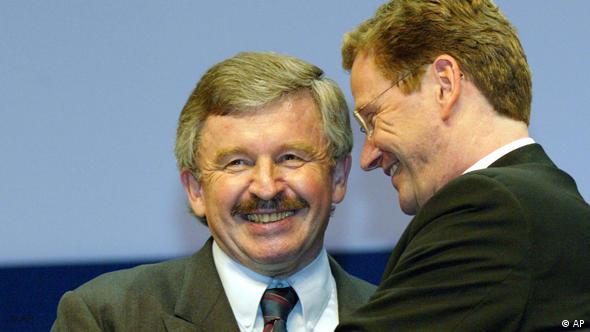 A laughing Guido Westerwelle being embraced by Guido Westerwelle in 2002