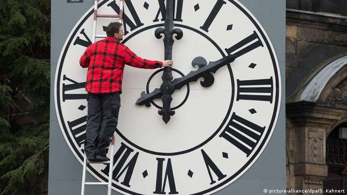 A man fixes a clock in Dresden, Germany