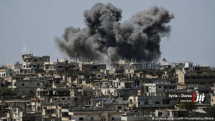 Smoke rises over a building in Daraa province after it was hit by a bomb