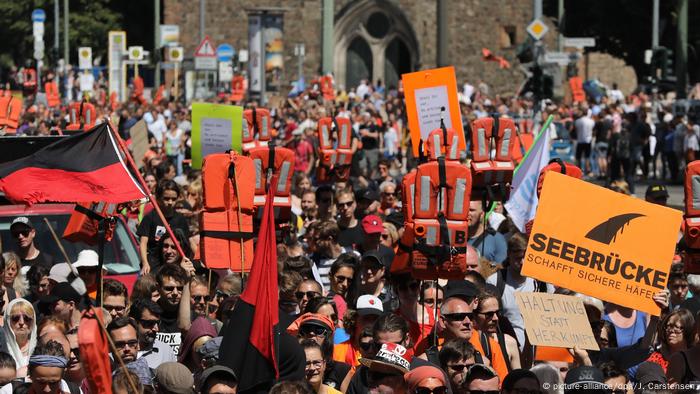 Demonstranten halten während einer Demonstration in Berlin Schwimmwesten und Plakate hoch, um Rettungsaktionen für Migranten im Mittelmeer zu unterstützen (Bildbündnis / dpa / J. Carstensen)