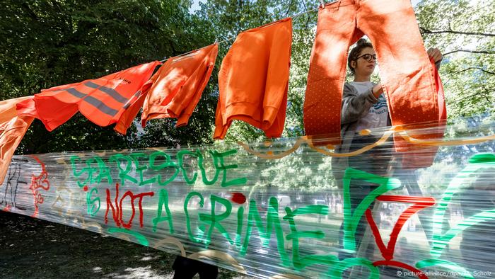 Eine Frau stellt ein Schild mit der Aufschrift auf: Rettung auf See ist kein Verbrechen während einer Demonstration in Hamburg zur Unterstützung von Rettungsaktionen für Migranten im Mittelmeer (Bildbündnis / dpa / M. Scholz)