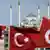 Turkish flags wave in front of a backdrop of the Istanbul skyline
