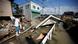 A local resident walks on submerged and destroyed houses in a flooded area in Mabi district of Kurashiki A local resident walks on submerged and destroyed houses in a flooded area in Mabi district of Kurashiki