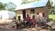 Refugee children sit in front of an unfinished house structure Refugee children sit in front of an unfinished house structure