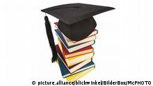 Doktorhut auf einem Buecherstapel, Symbolfoto fuer Bildung und Kompetenz | graduation cap on a stack of books, symbol picture for education and competence | Verwendung weltweit