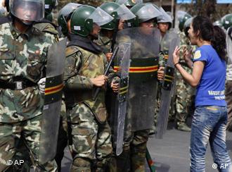 Uigurische Frau vor chinesischen Sicherheitskräften (Foto: AP)