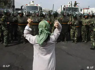 一名维族妇女在武警部队面前抗议